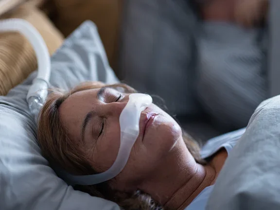 vrouw slaapt met canula in lakens en kussens